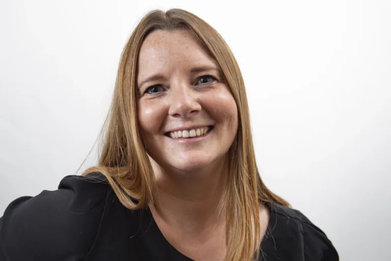 Headshot of a business woman smiling on a simple white background